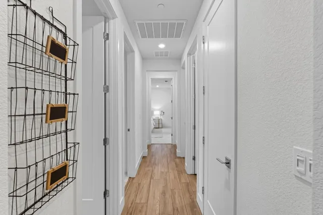 a view of a hallway with wooden floor and staircase