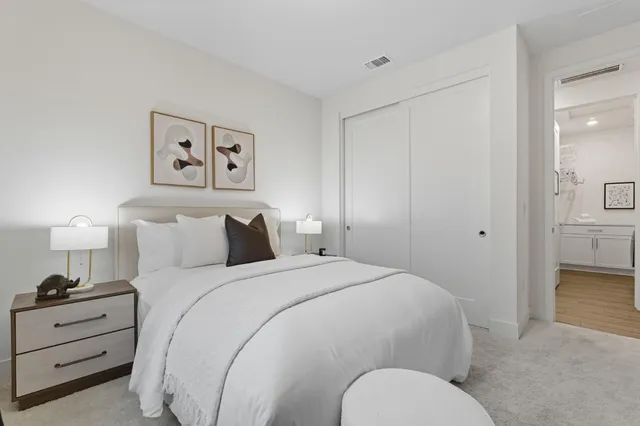 a spacious bedroom with a bed and a lamp