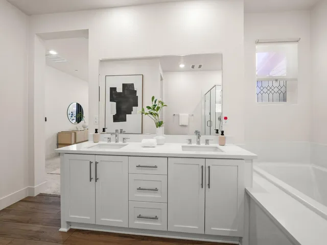 a bathroom with a sink double vanity granite tub and a mirror