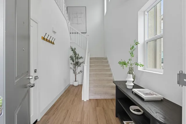 a view of a hallway with wooden floor and a potted plant