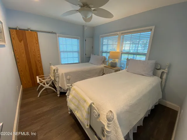 a spacious bedroom with two beds and a desk