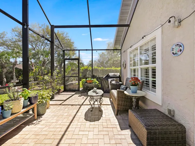 a living room with patio furniture and a floor to ceiling window