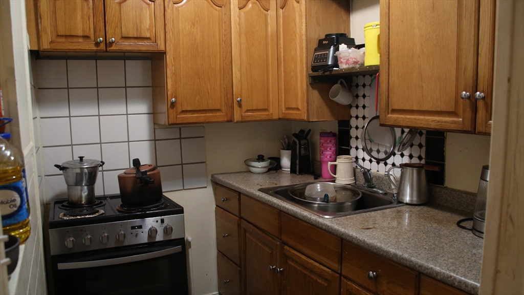 1951 Pleasant Street Fall River, MA 02723 - Photo 11 of 24 a kitchen with granite countertop a sink stainless steel appliances and cabinets