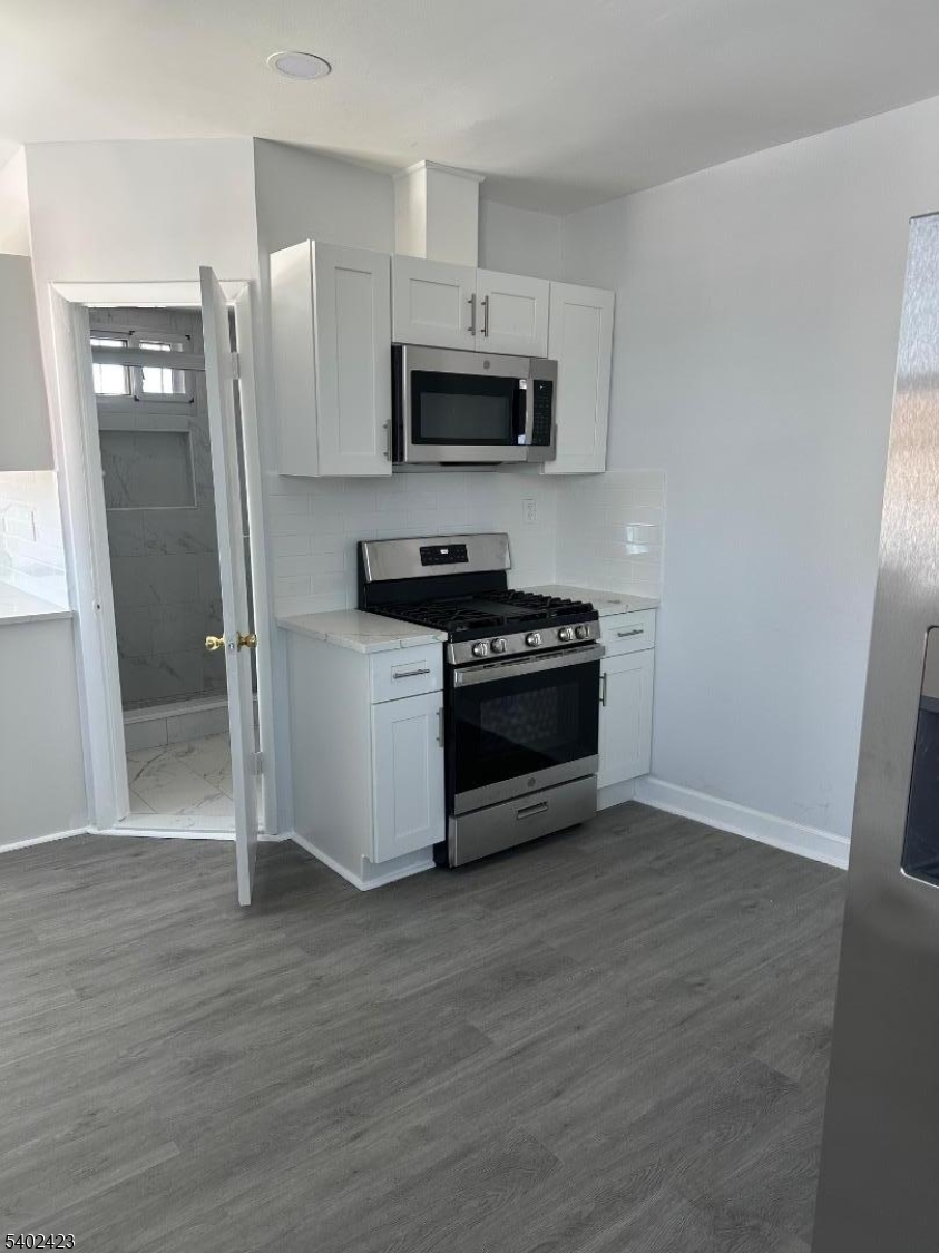 105 Broadway Newark, NJ 07104 - Photo 2 of 9 a kitchen with stainless steel appliances a refrigerator stove and microwave