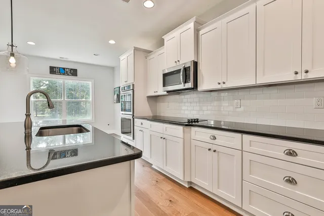 a kitchen with stainless steel appliances granite countertop a sink stove and microwave