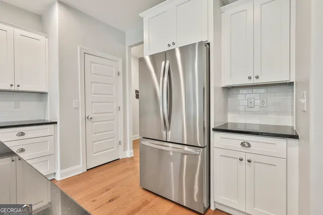 a kitchen with white cabinets and stainless steel appliances