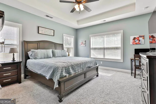 a spacious bedroom with a bed and a chandelier