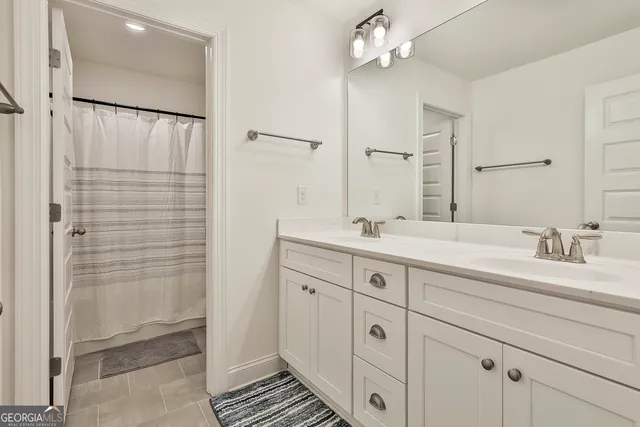 a bathroom with a double vanity sink a mirror and a shower