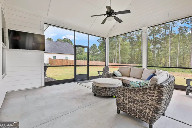 a living room with furniture and a floor to ceiling window