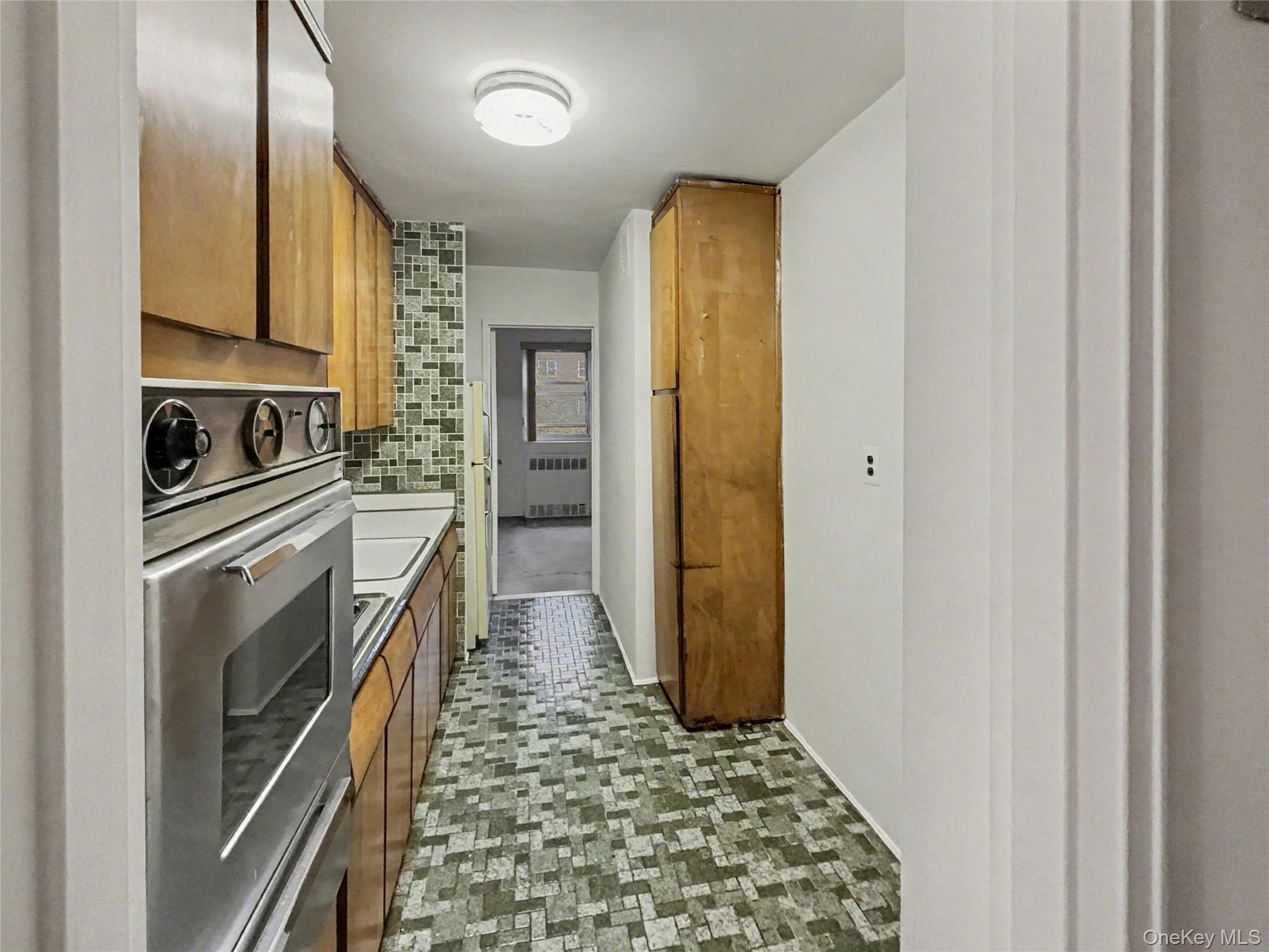 88-08 151st Avenue, Unit 3H Queens, NY 11414 - Photo 6 of 13 a kitchen with granite countertop a refrigerator and a stove