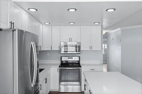 a kitchen with a refrigerator and a stove top oven