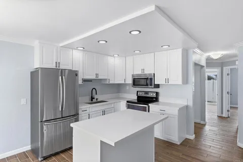 a kitchen with stainless steel appliances a refrigerator sink and microwave