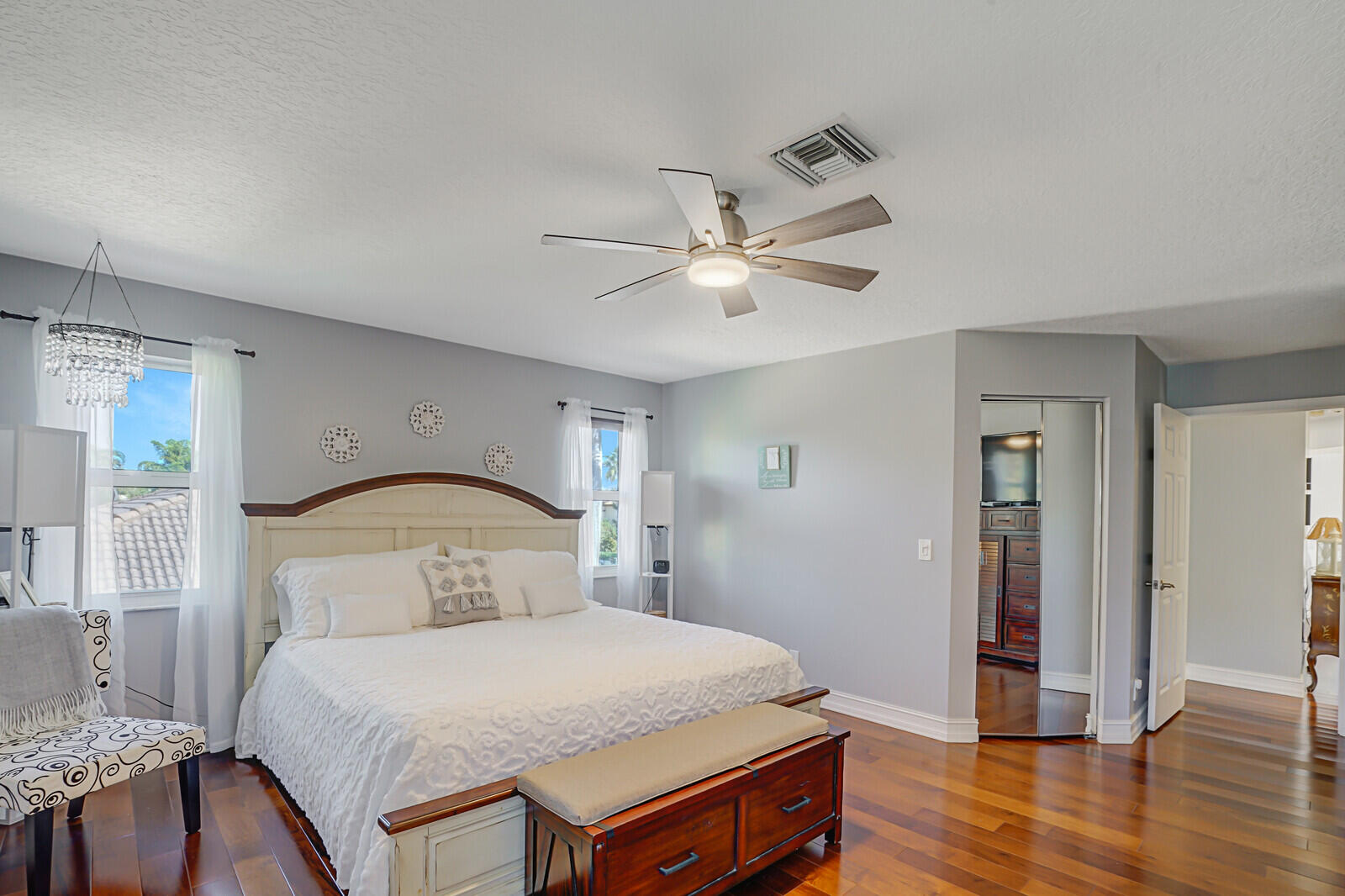 8599 Cypress Springs Road Lake Worth, FL 33467 - Photo 34 of 59 a bedroom with a bed and a chandelier