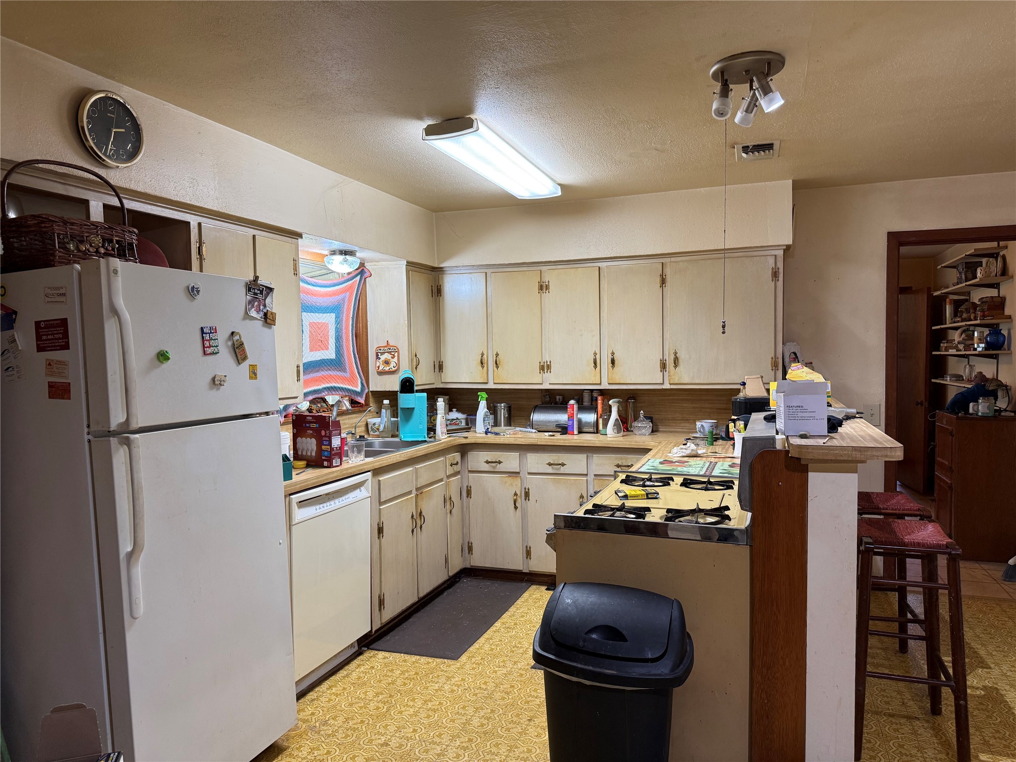 2607 Lilac Street Pasadena, TX 77503 - Photo 4 of 12 a kitchen with a refrigerator a stove top oven a sink and cabinets