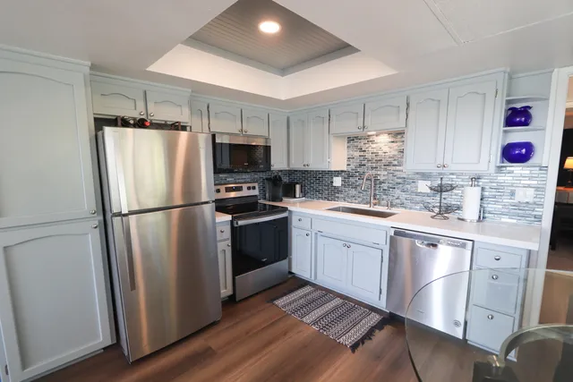 a kitchen with granite countertop a refrigerator stove top oven and sink