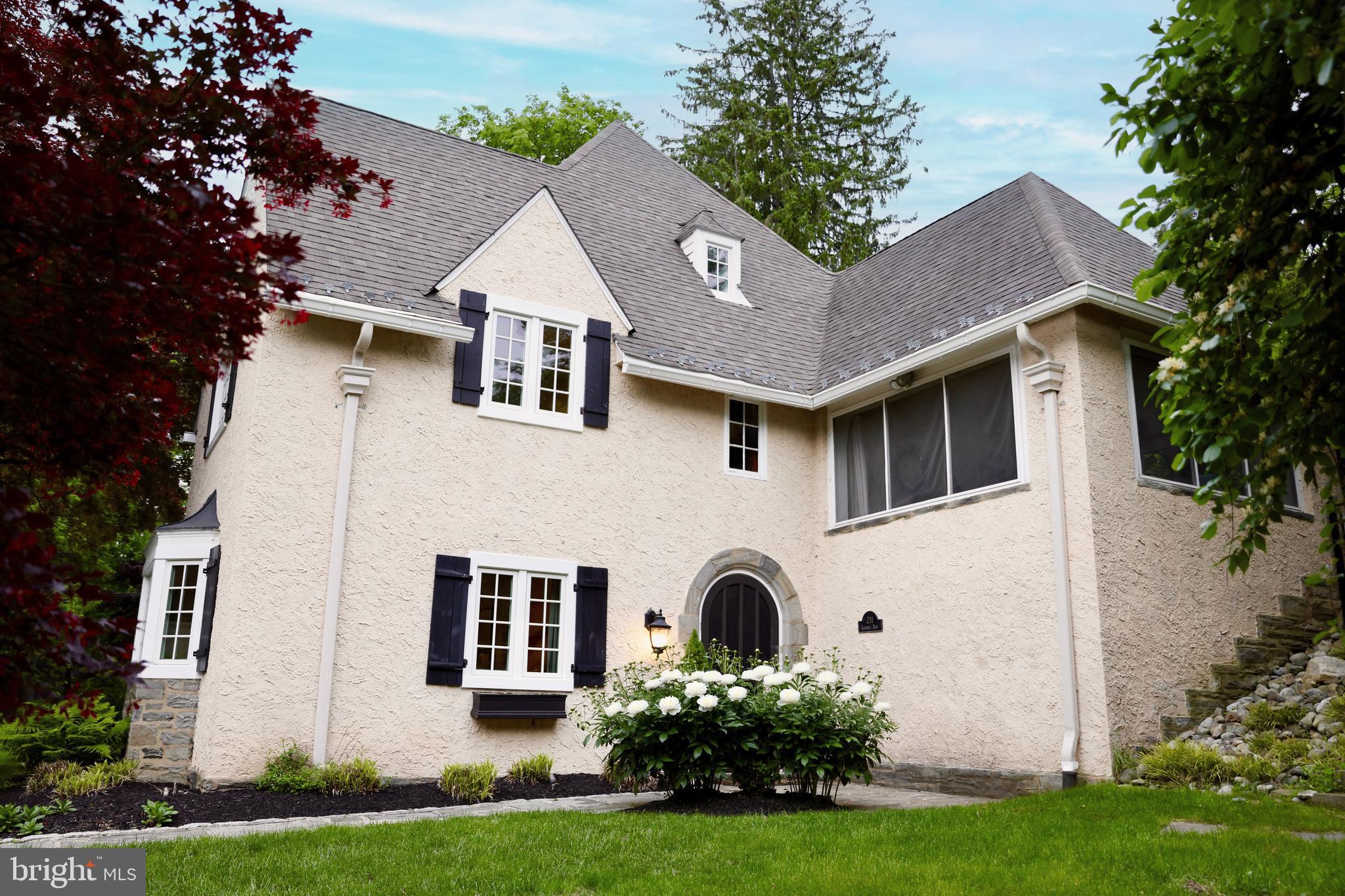 211 Ladbroke Road Bryn Mawr, PA 19010 - Photo 1 of 38 a front view of a house with a yard and garage