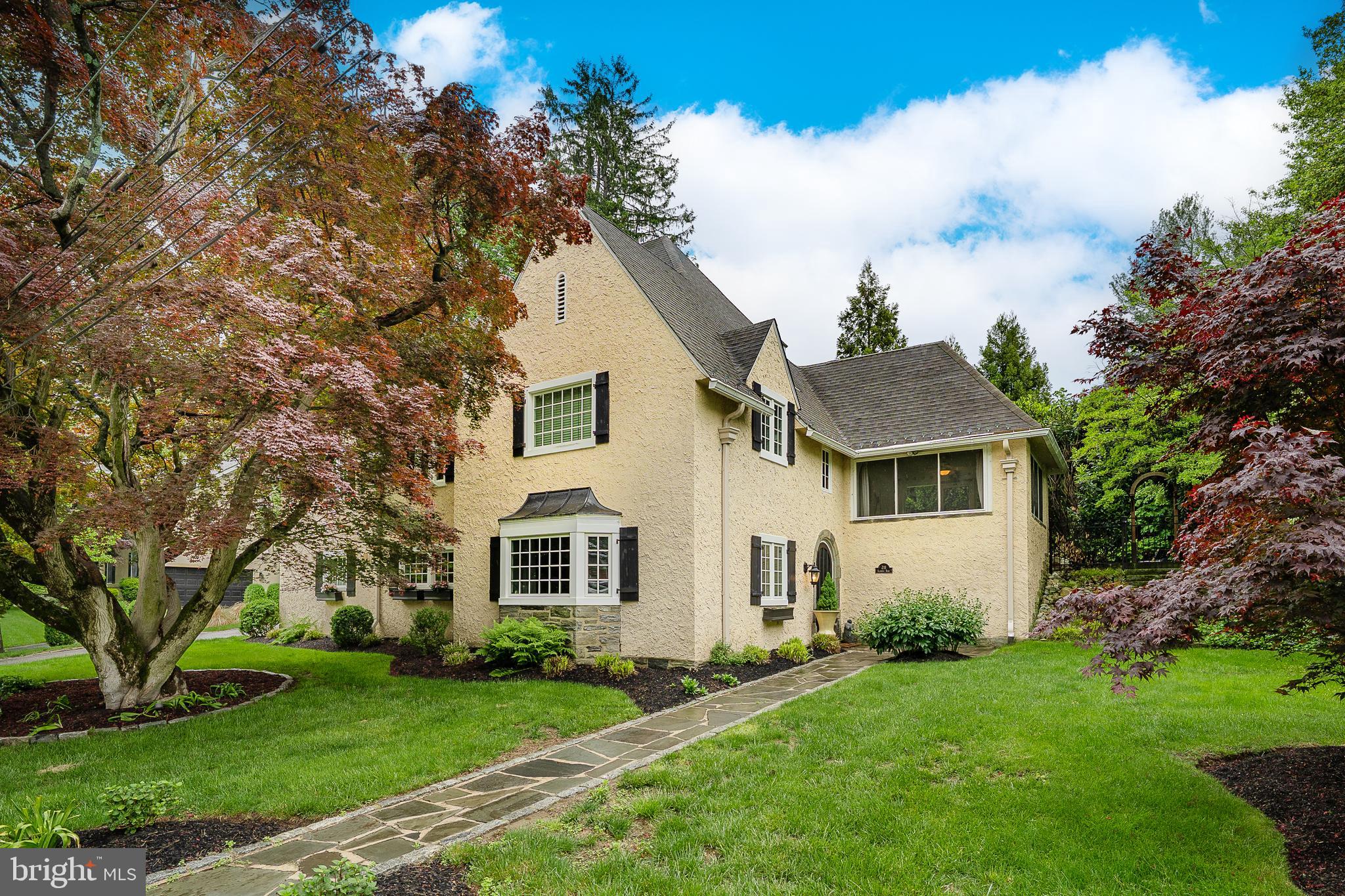 211 Ladbroke Road Bryn Mawr, PA 19010 - Photo 4 of 38 a view of a yard in front of a house with plants and large tree