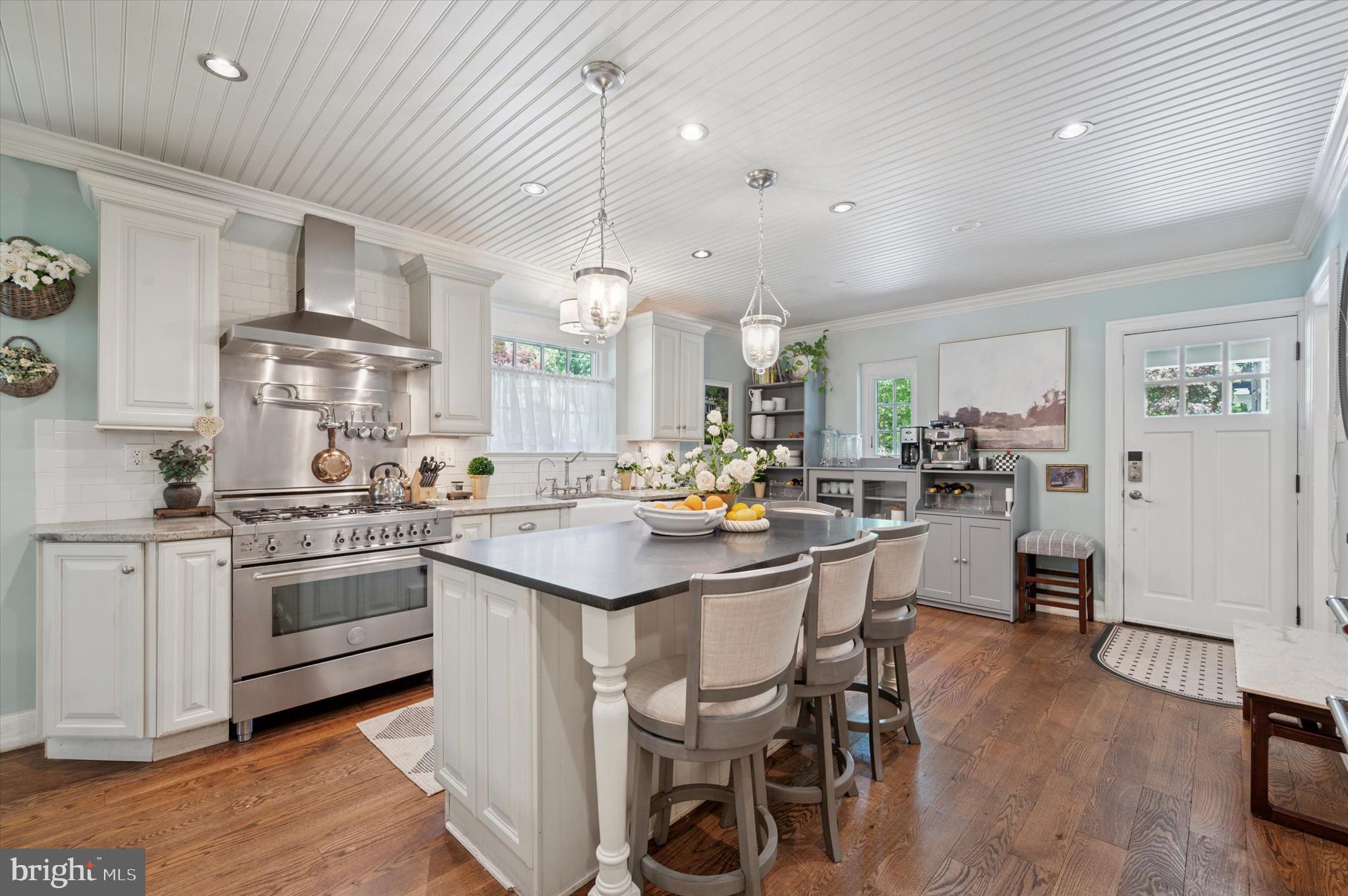 211 Ladbroke Road Bryn Mawr, PA 19010 - Photo 9 of 38 a kitchen with stainless steel appliances a sink a stove a table and chairs