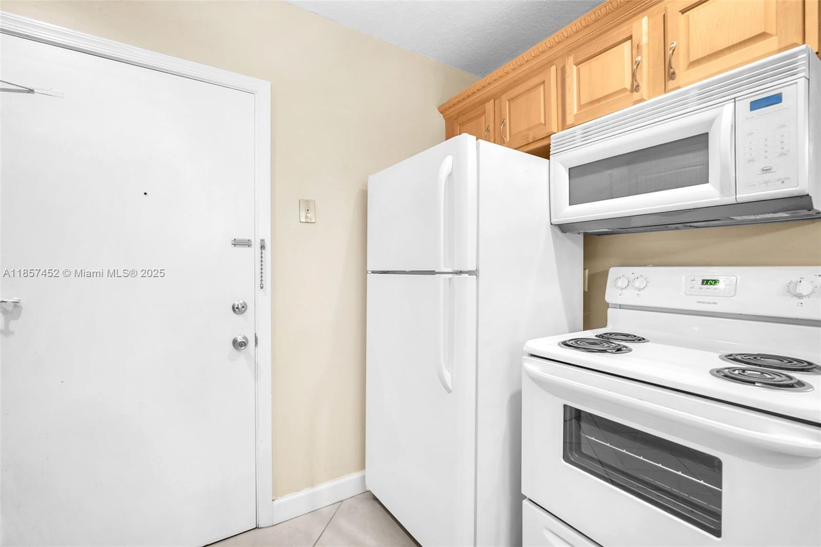2171 Northeast 66th Street, Unit 801 Fort Lauderdale, FL 33308 - Photo 18 of 31 a white refrigerator freezer and a stove sitting inside of a kitchen
