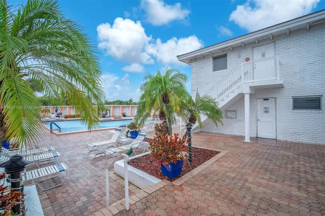 a vase of flowers sitting on a floor in front of a house