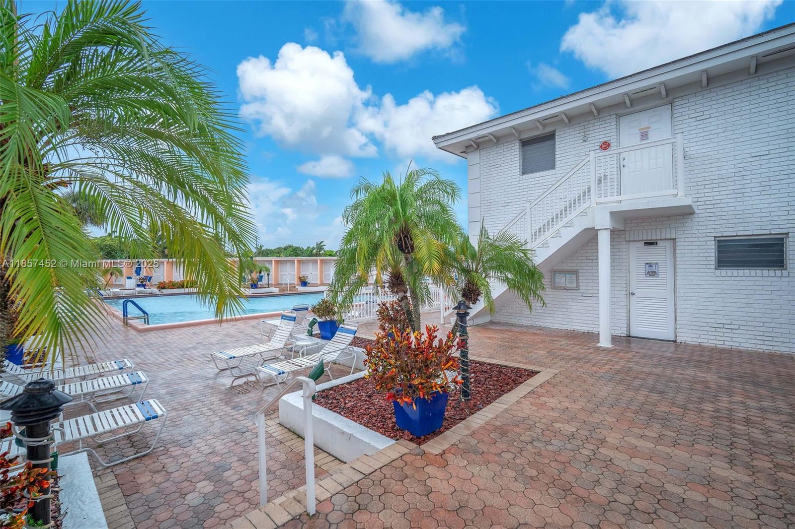 2171 Northeast 66th Street, Unit 801 Fort Lauderdale, FL 33308 - Photo 25 of 31 a vase of flowers sitting on a floor in front of a house