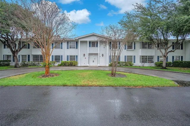 a front view of a house with a yard and trees