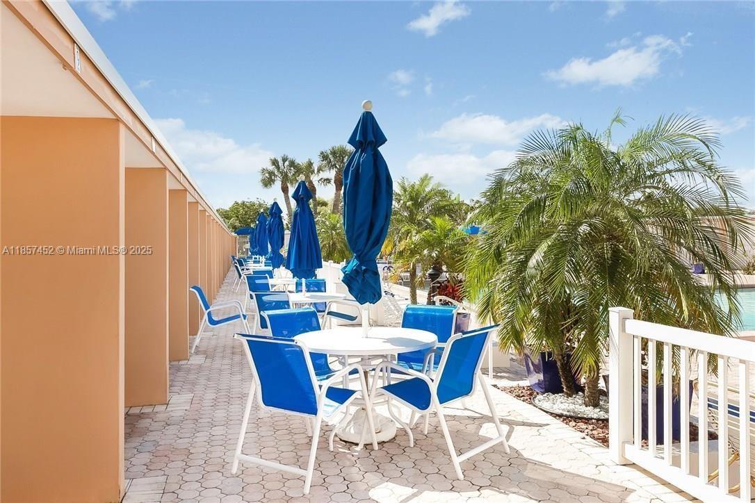 2171 Northeast 66th Street, Unit 801 Fort Lauderdale, FL 33308 - Photo 4 of 31 a view of a patio with table and chairs and potted plants