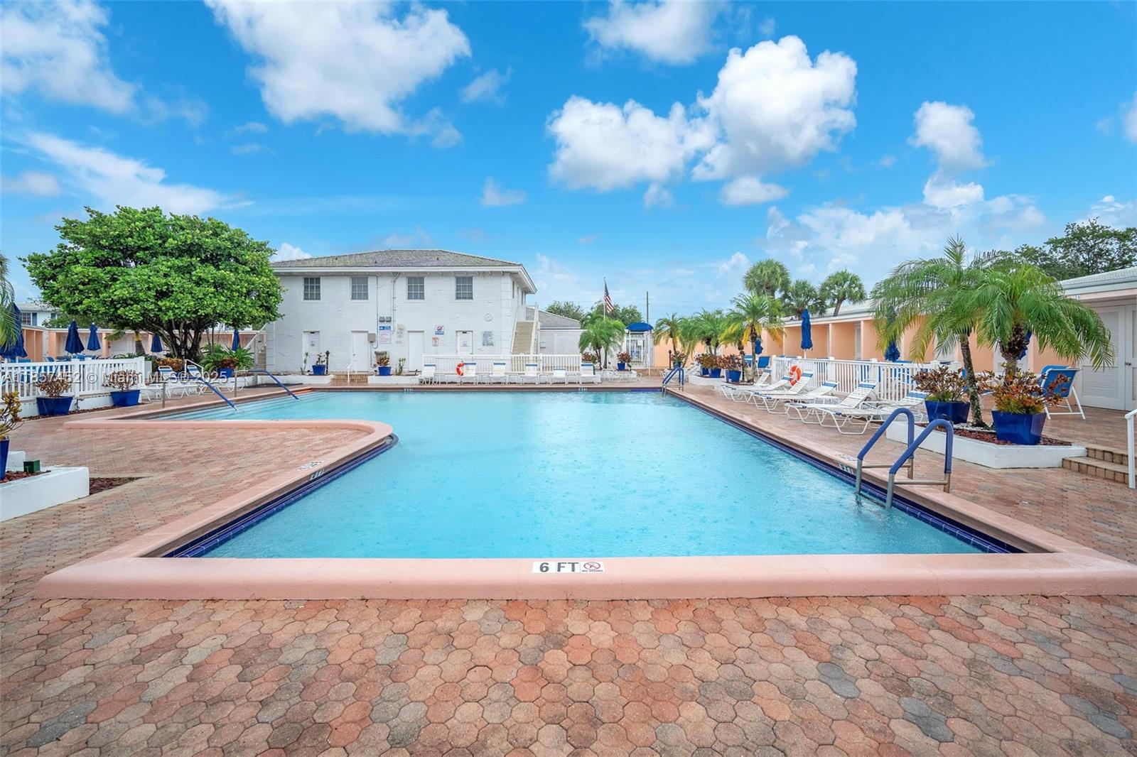 2171 Northeast 66th Street, Unit 801 Fort Lauderdale, FL 33308 - Photo 5 of 31 a view of a swimming pool with a lawn chairs under an umbrella