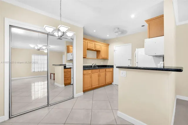 a large kitchen with granite countertop a refrigerator a stove a sink and a dining table