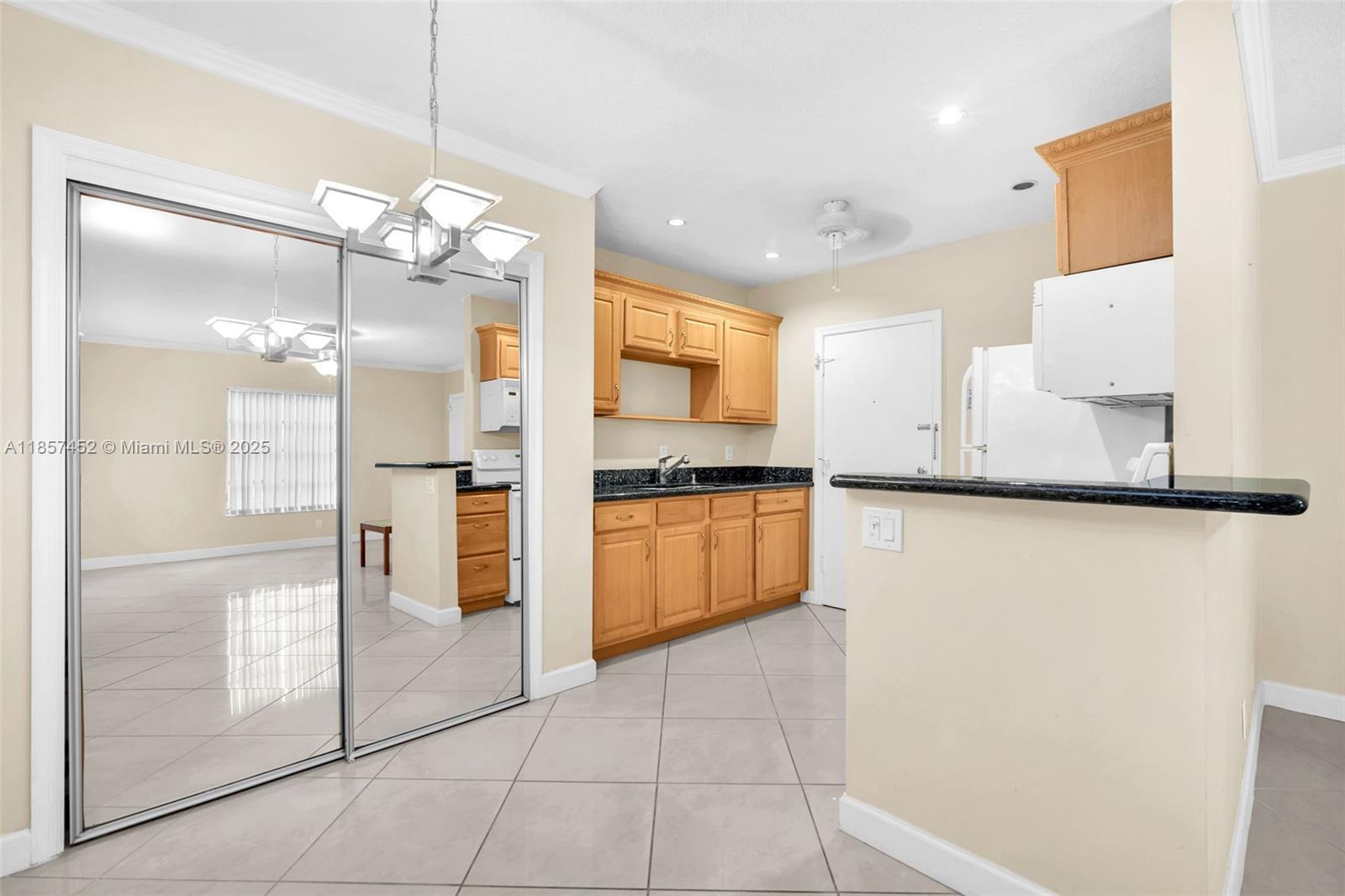 2171 Northeast 66th Street, Unit 801 Fort Lauderdale, FL 33308 - Photo 8 of 31 a large kitchen with granite countertop a refrigerator a stove a sink and a dining table