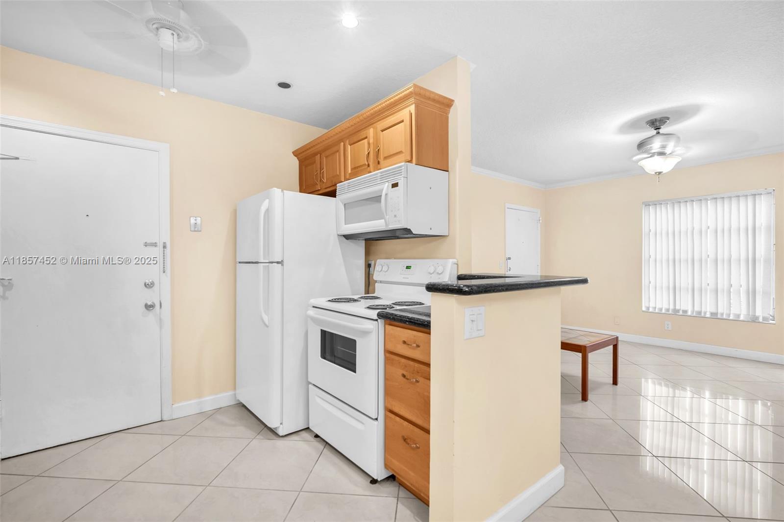 2171 Northeast 66th Street, Unit 801 Fort Lauderdale, FL 33308 - Photo 9 of 31 a kitchen with stainless steel appliances granite countertop a refrigerator a stove a sink and white cabinets