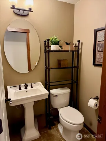 a bathroom with a toilet sink and mirror