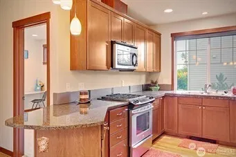 a kitchen with stainless steel appliances granite countertop a sink stove and cabinets