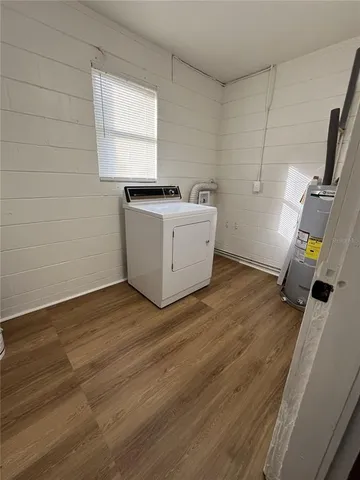 a view of a kitchen with wooden floor and electronic appliances