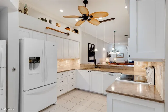 a kitchen with stainless steel appliances granite countertop a sink a refrigerator and a granite counter tops