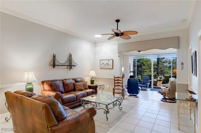 a living room with furniture ceiling fan and a window