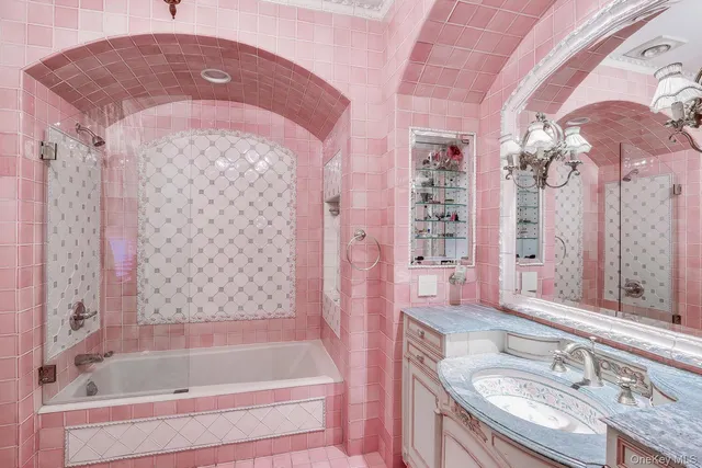 a bathroom with a granite countertop bathtub shower sink vanity and mirror