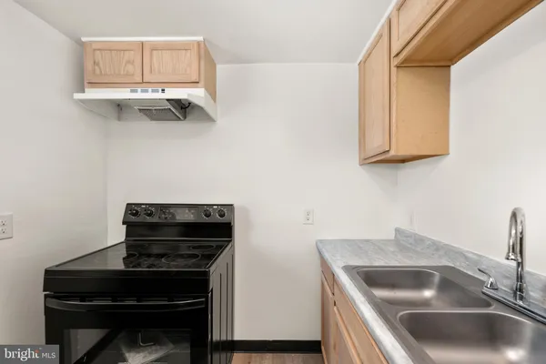 a kitchen with granite countertop a sink and a stove