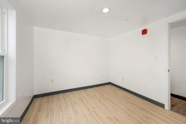 a view of empty room with wooden floor and entryway