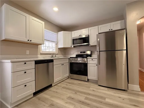 a kitchen with granite countertop white cabinets and window