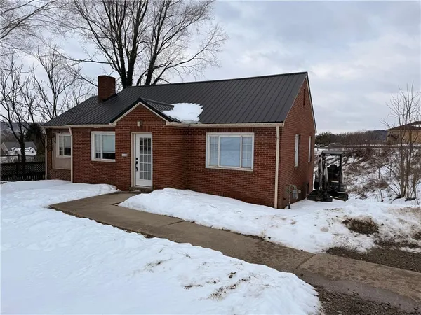 a front view of a house with a yard covered in snow