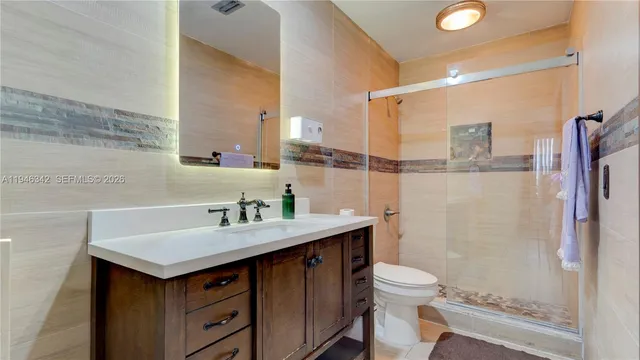 a bathroom with a sink toilet a mirror and shower