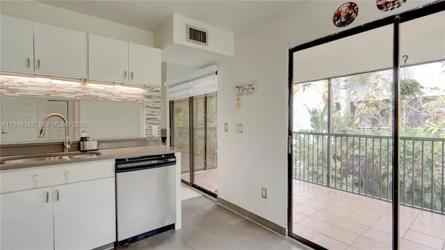 a kitchen with granite countertop a sink and a refrigerator
