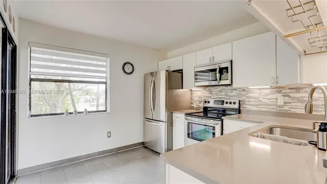 a kitchen with granite countertop a stove a sink and a microwave