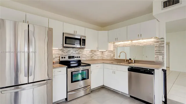 a kitchen with stainless steel appliances a sink stove and refrigerator