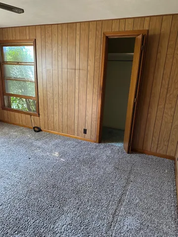 an empty room with windows and closet