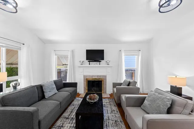 a living room with furniture a fireplace and a flat screen tv
