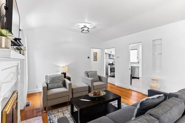 a living room with furniture a fireplace and a flat screen tv