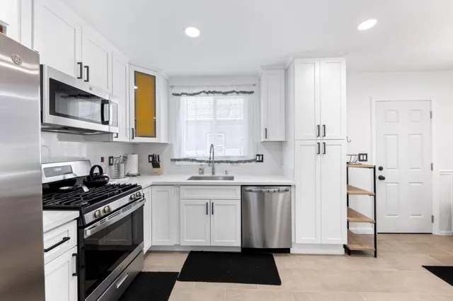 a kitchen with stainless steel appliances a stove a sink and a microwave