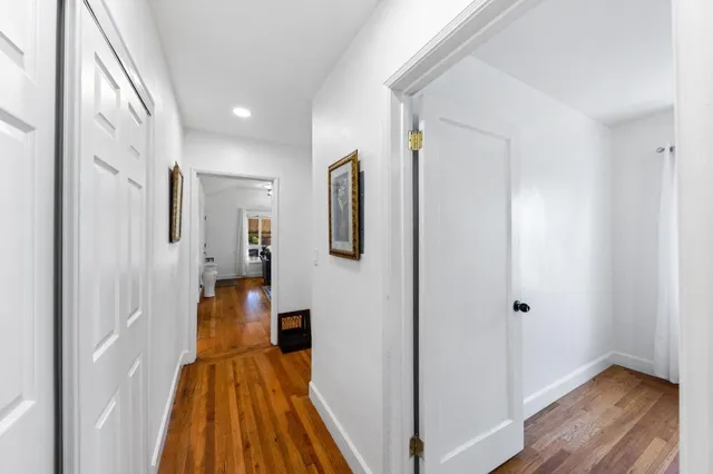 a view of a hallway with wooden floor and staircase